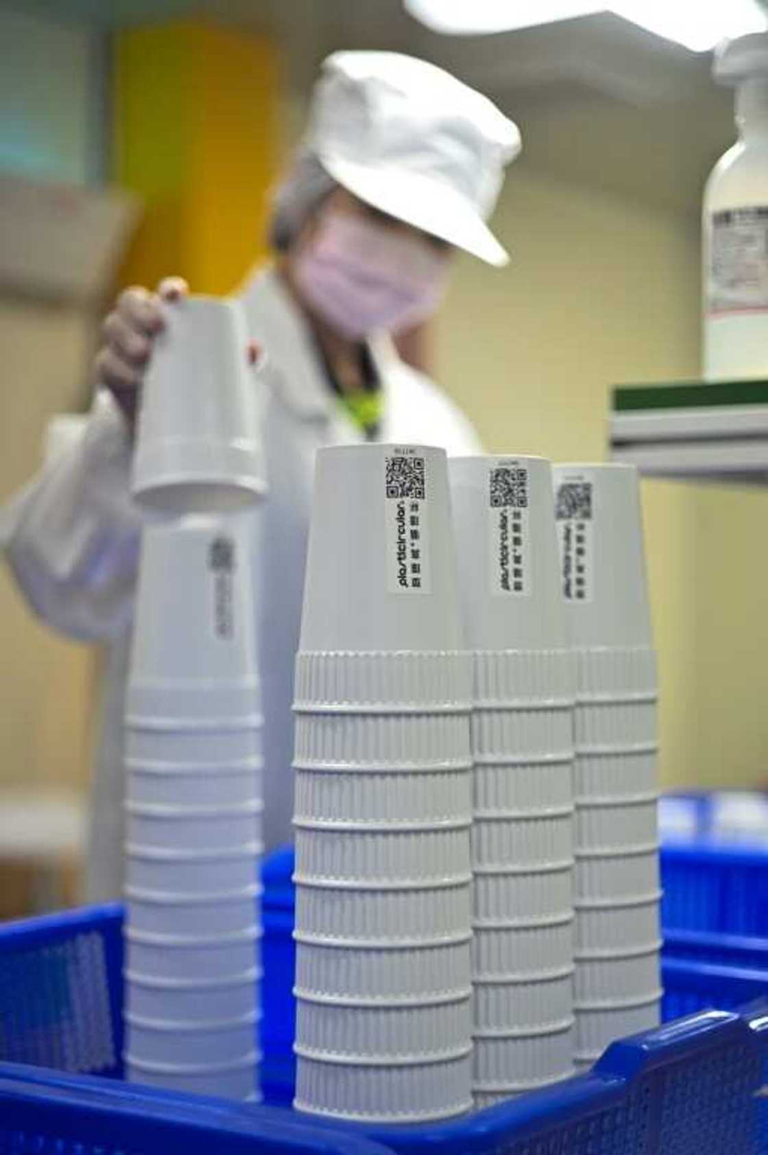 A staff member from Taiwan's Blue Ocean, an environmental protection company, examines a reusable mug A staff member from Taiwan's Blue Ocean, an environmental protection company, examines a reusable mug