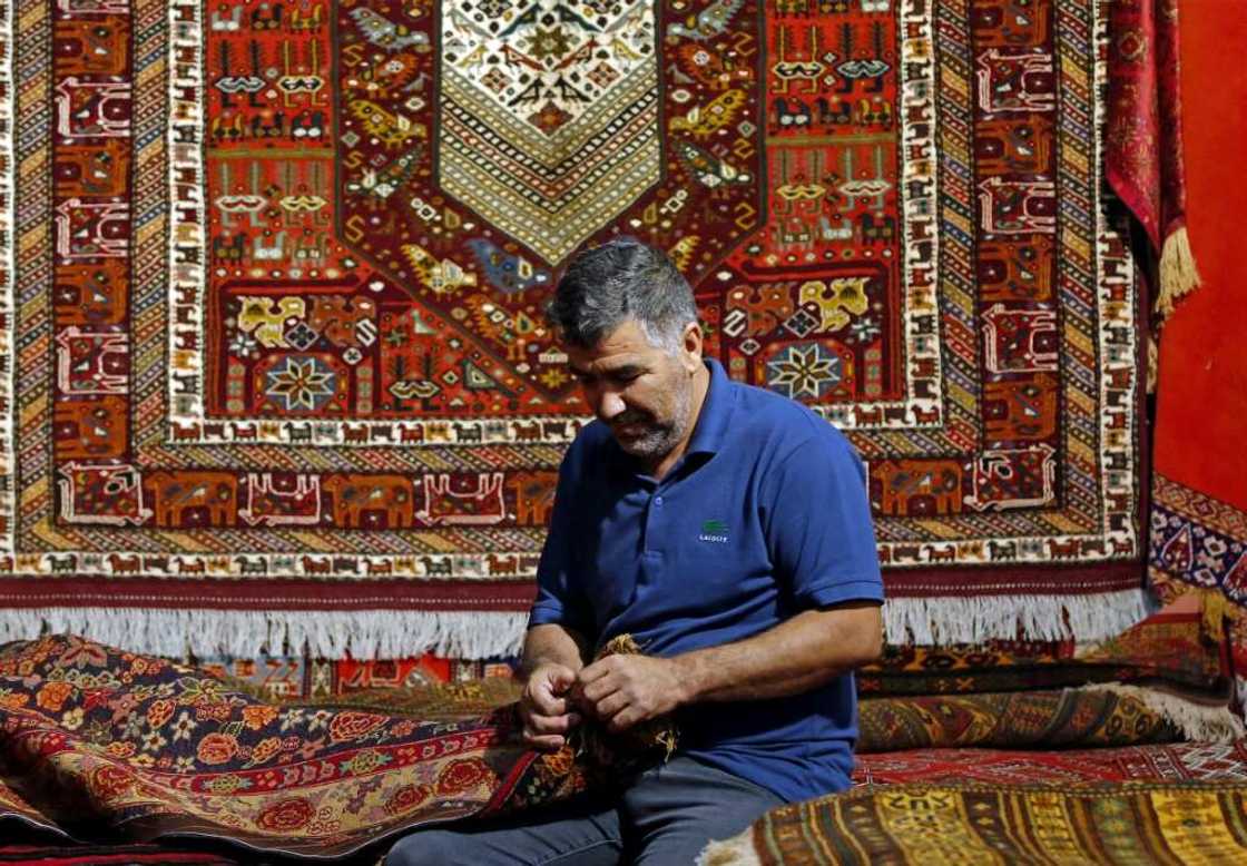 Rugs traditionally woven in the Islamic republic feature dense designs, often with curving floral patterns, in rich colours Rugs traditionally woven in the Islamic republic feature dense designs, often with curving floral patterns, in rich colours