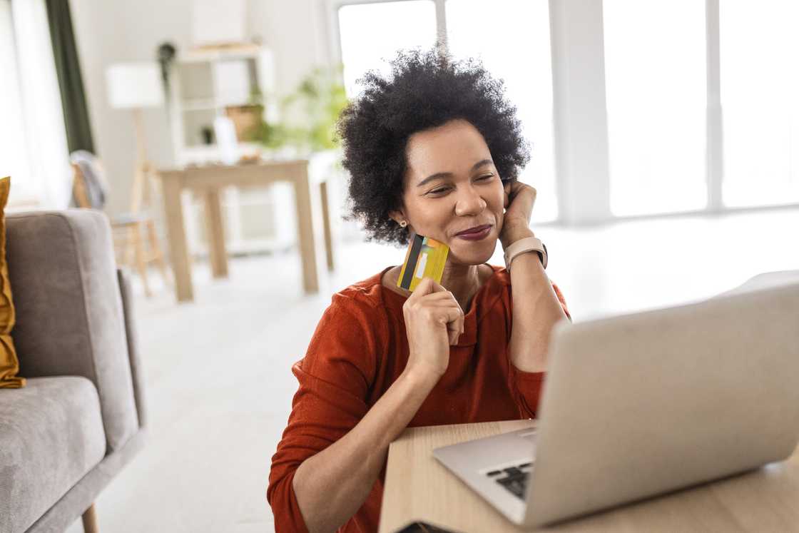 A lady smiles as looks at her laptop's screen A lady smiles as looks at her laptop's screen