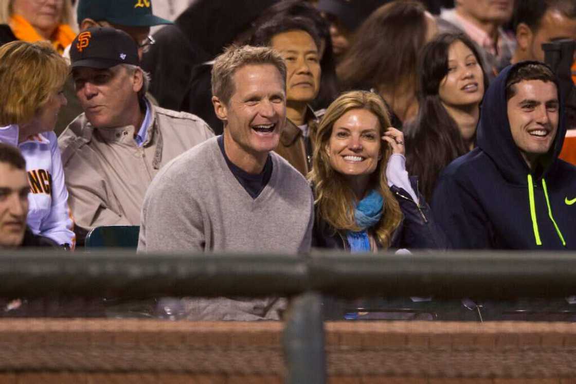 Steve Kerr and his wife watch a basketball game