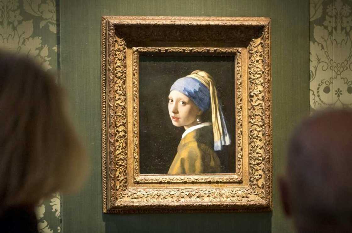 Two activists glued themselves to Johannes Vermeer's 'Girl with a Pearl Earring' and the adjoining wall, but the artwork was behind glass and undamaged