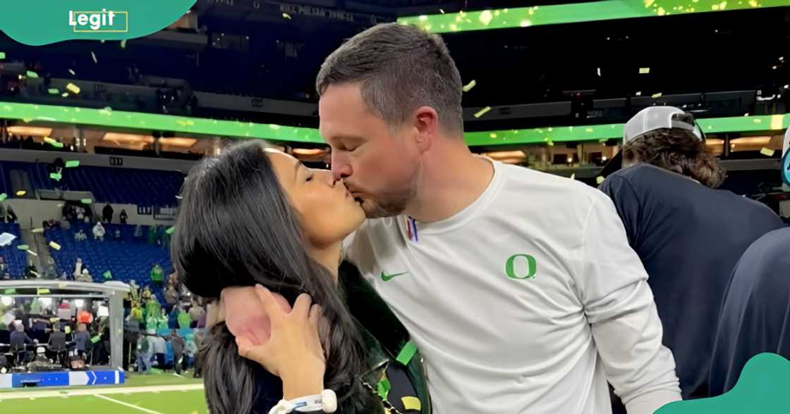 Sauphia Lanning (L) and her husband, Dan Lanning (R) kiss after a football match.