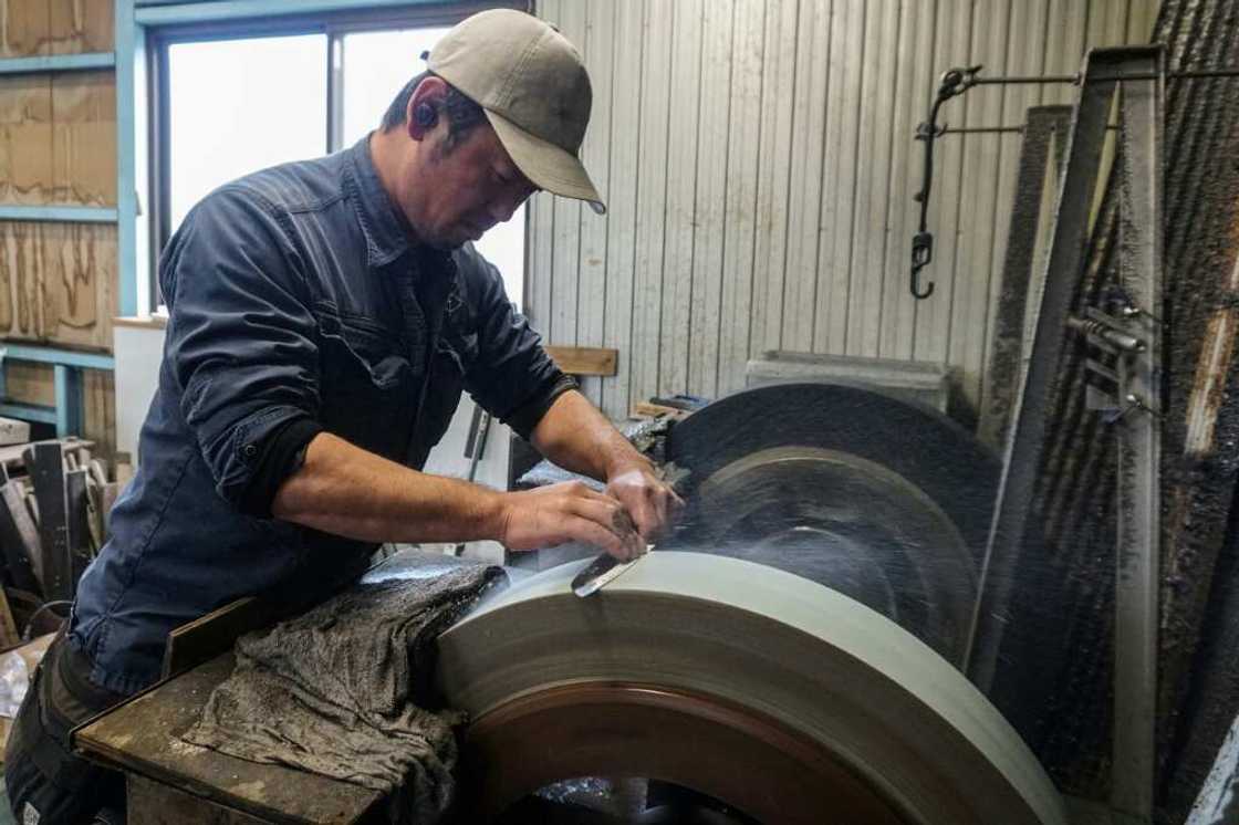 Yoshihiro Yauji sharpens a freshly forged 'santoku', a multipurpose knife, at the Takefu Knife Village in Fukui prefecture Yoshihiro Yauji sharpens a freshly forged 'santoku', a multipurpose knife, at the Takefu Knife Village in Fukui prefecture