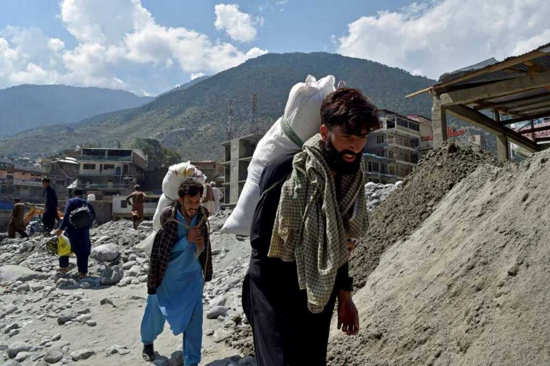 Locals have to carry supplies to remote villagers by foot after roads and bridges were destroyed Locals have to carry supplies to remote villagers by foot after roads and bridges were destroyed