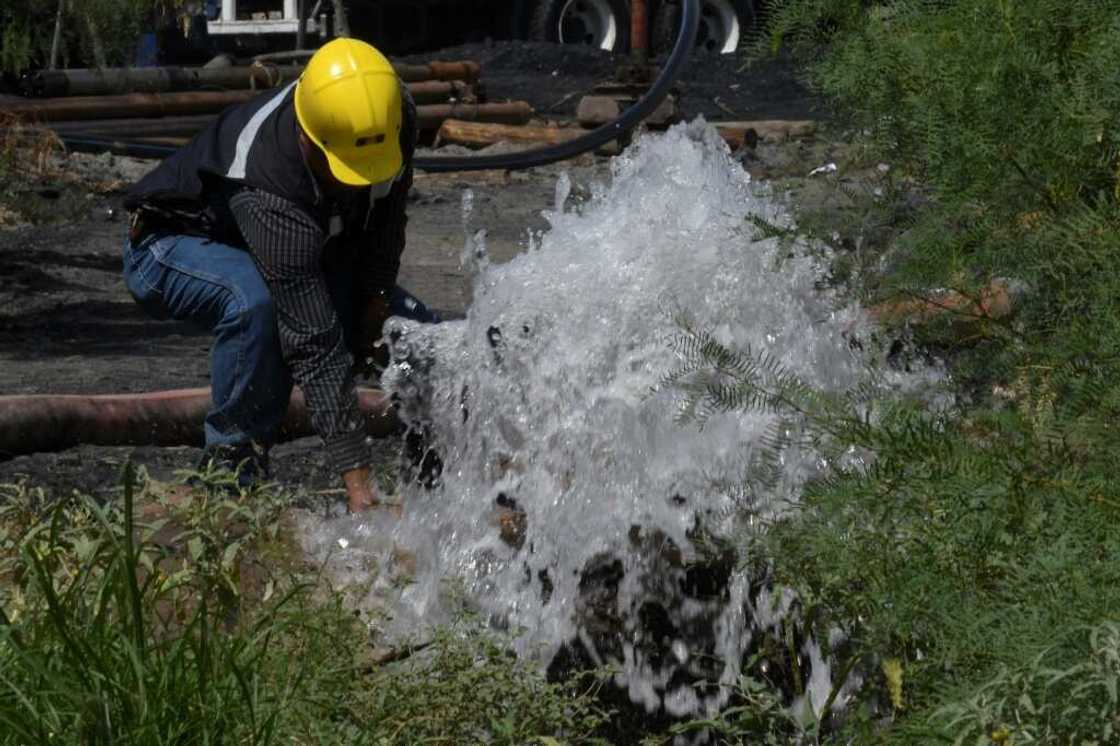 A rescuer works with a hose at a flooded mine in northern Mexico