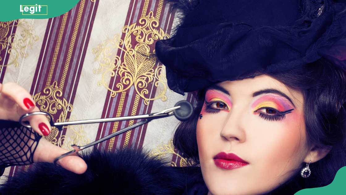 Young lady in vintage hat and with creative visage and forceps Young lady in vintage hat and with creative visage and forceps