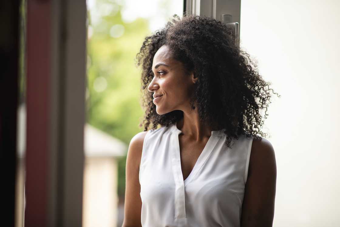 A woman reflecting by the window