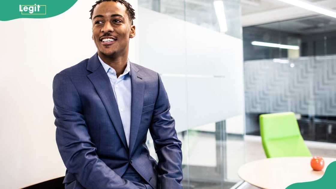 A man sitting on an office table A man sitting on an office table