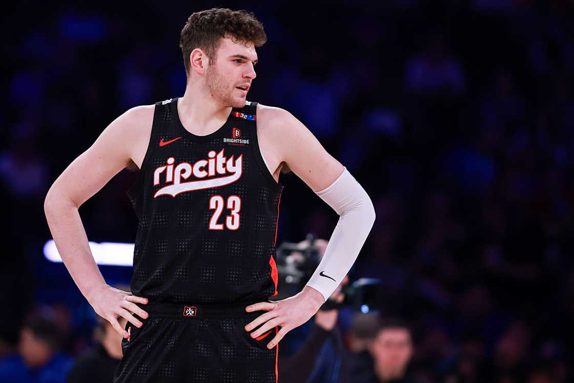 Donovan Clingan looks on as he holds his waist during a game Donovan Clingan looks on as he holds his waist during a game