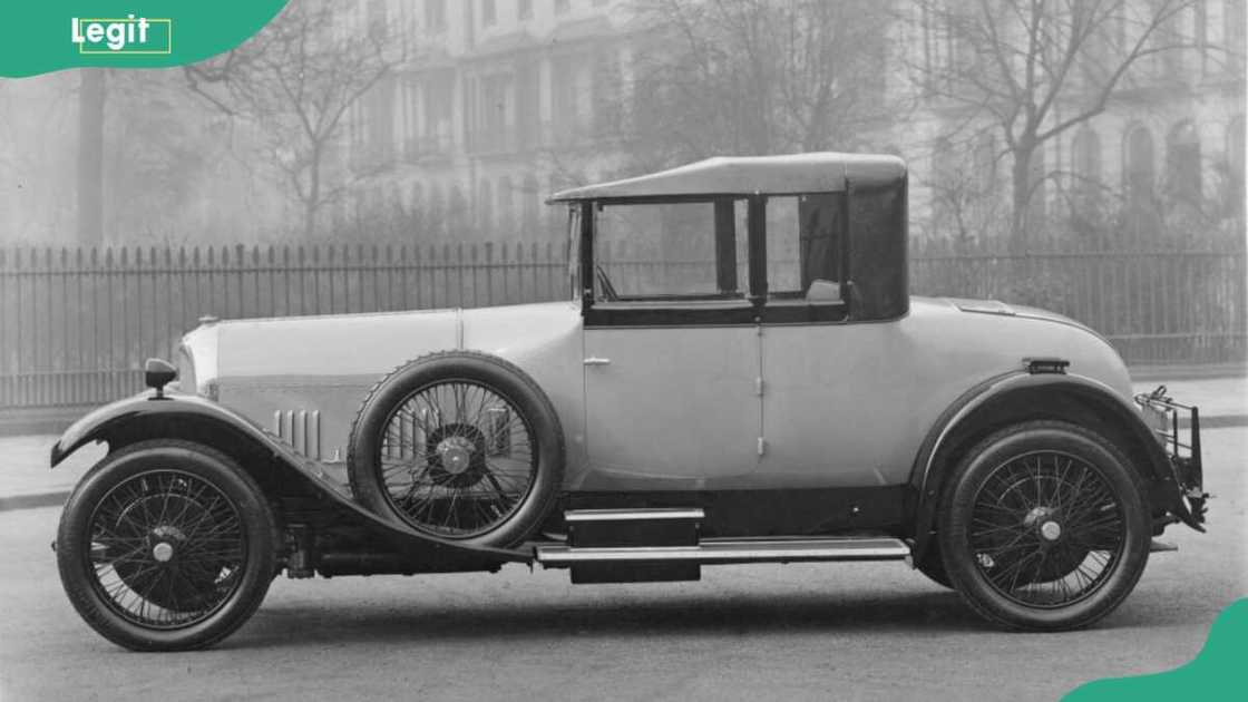 Bentley 3 litre parked outside a large house fenced