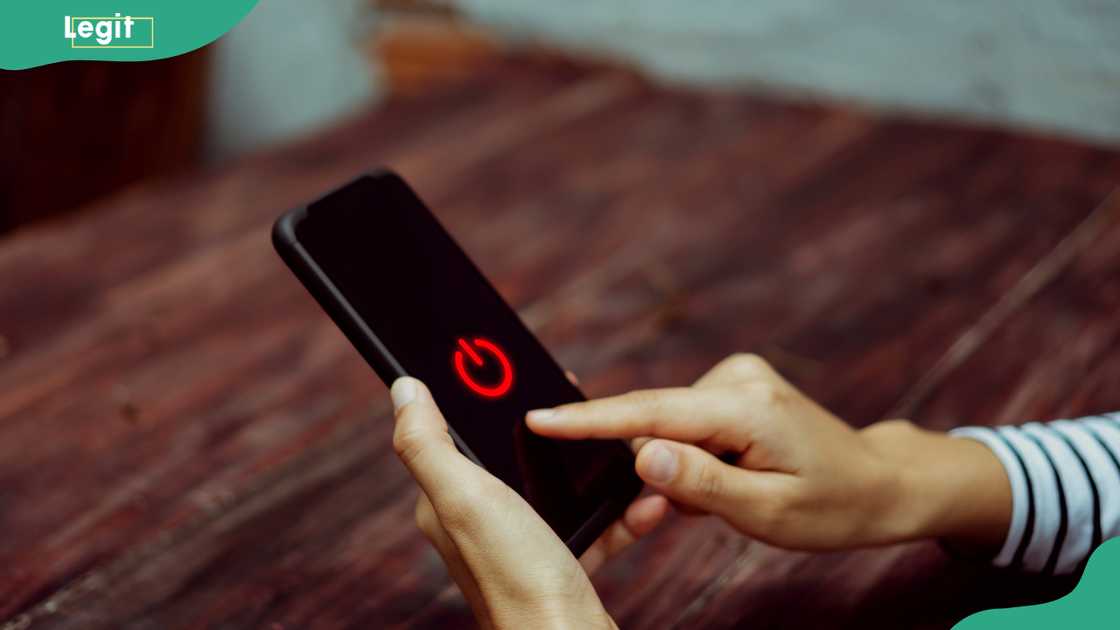 Woman hand using smartphone to restart.