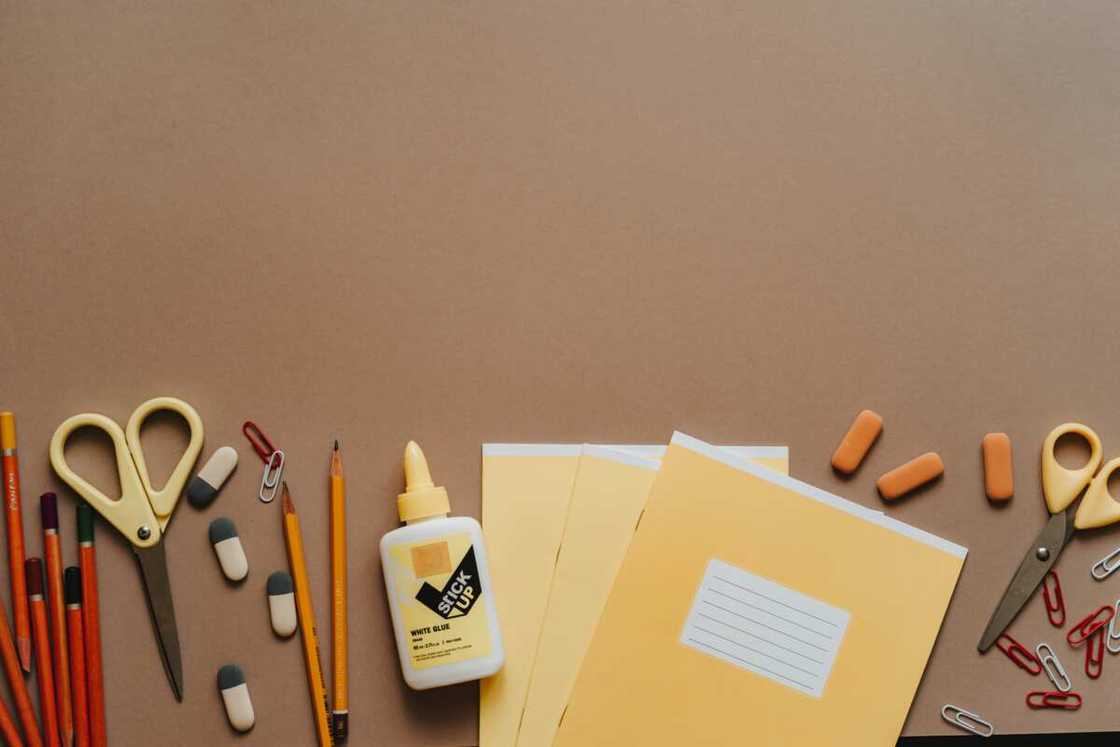 Assorted office stationery on a brown surface Assorted office stationery on a brown surface