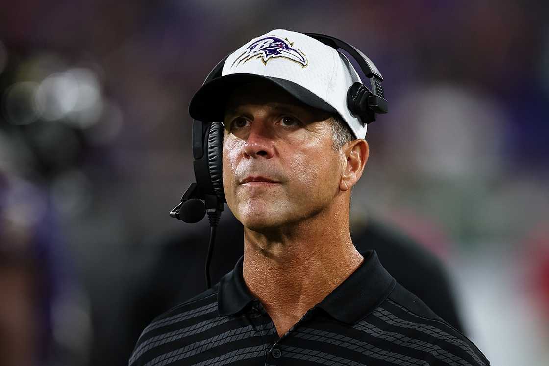 John Harbaugh wears a headset during a match.