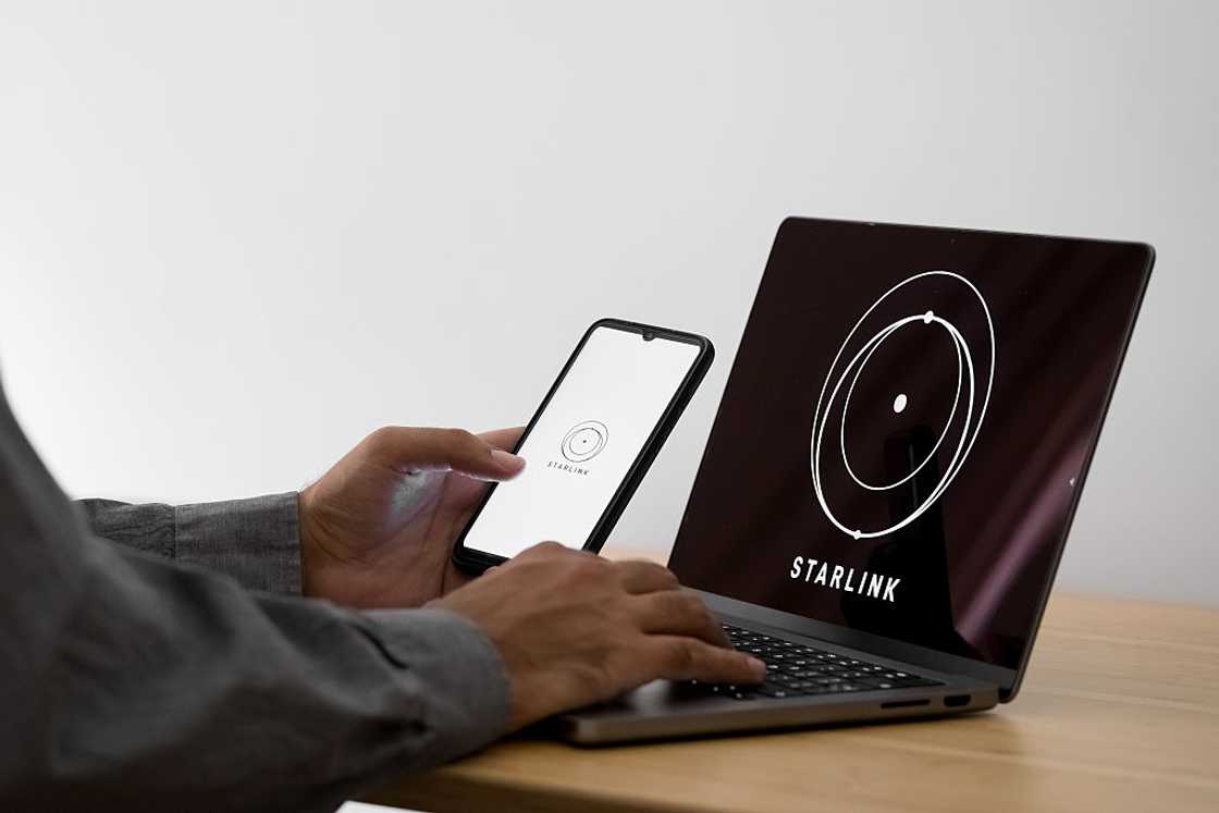 The Starlink logo on a phone and laptop screens The Starlink logo on a phone and laptop screens