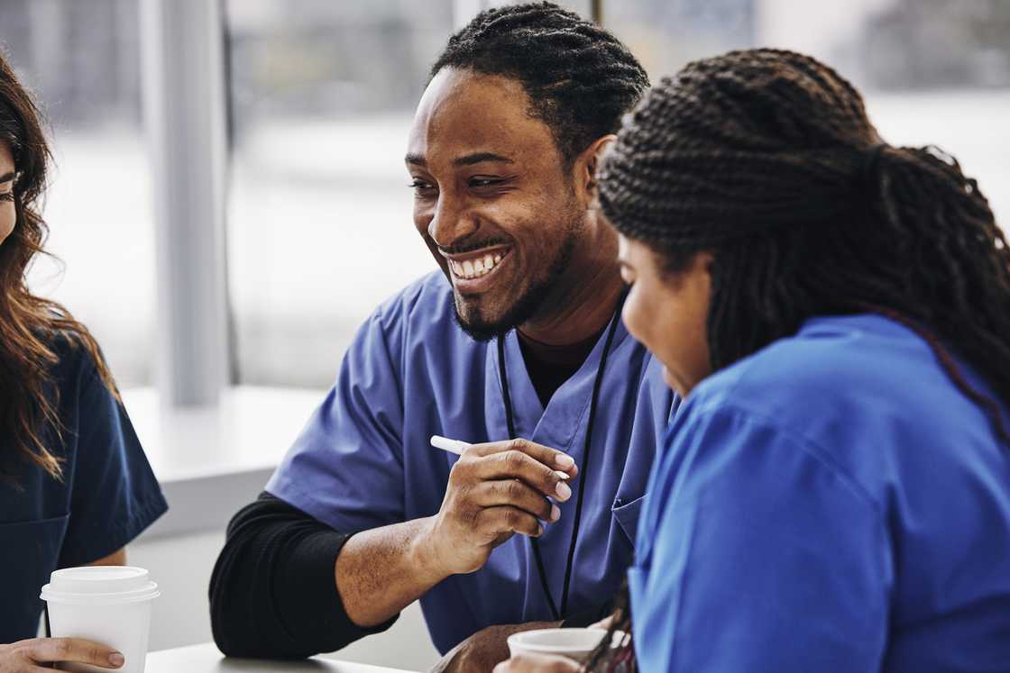 Cheerful nurse with female colleagues in hospital Cheerful nurse with female colleagues in hospital
