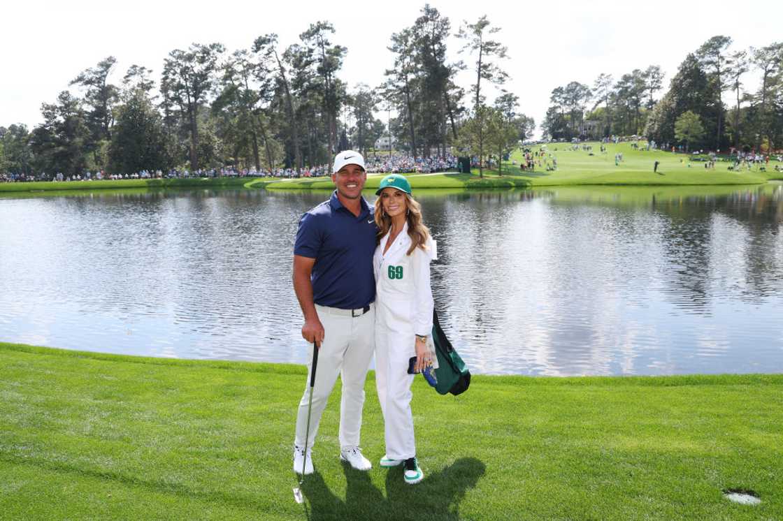 Brooks Koepka and Jena Sims Koepka poses for a photo on a golf course