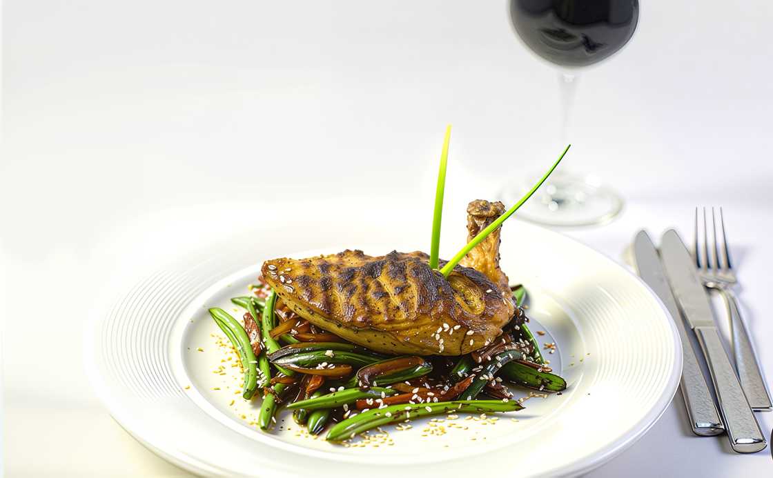 A plate of grilled chicken served on a bed of vegetables and a wine glass at the Ekaabo Restaurant and Terrace A plate of grilled chicken served on a bed of vegetables and a wine glass at the Ekaabo Restaurant and Terrace