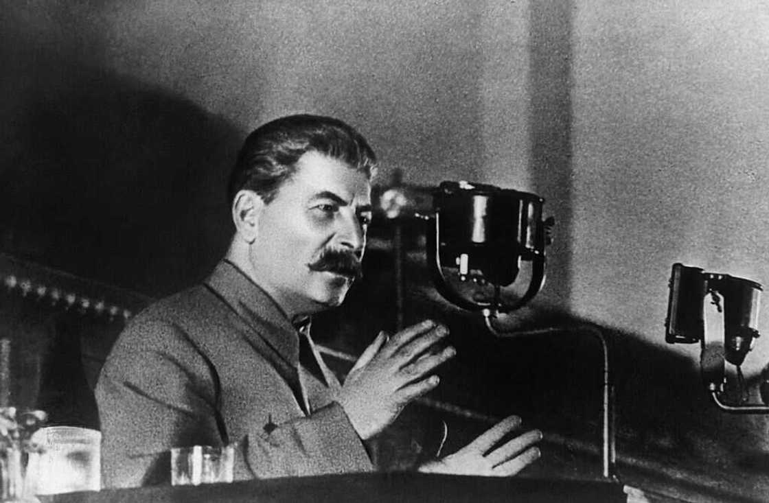 A black and white photo of Joseph Stalin making an address A black and white photo of Joseph Stalin making an address