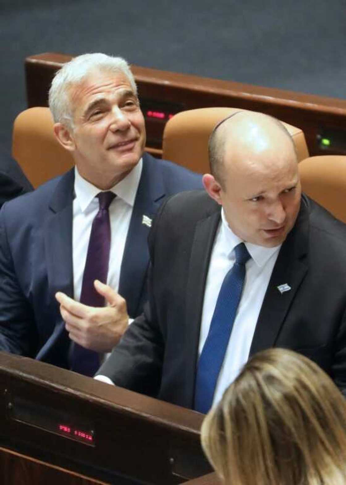Israeli Foreign Minister Yair Lapid (L) and Prime Minister Naftali Bennett (R) attend the preliminary vote on a bill to dissolve parliament and call an early election Israeli Foreign Minister Yair Lapid (L) and Prime Minister Naftali Bennett (R) attend the preliminary vote on a bill to dissolve parliament and call an early election