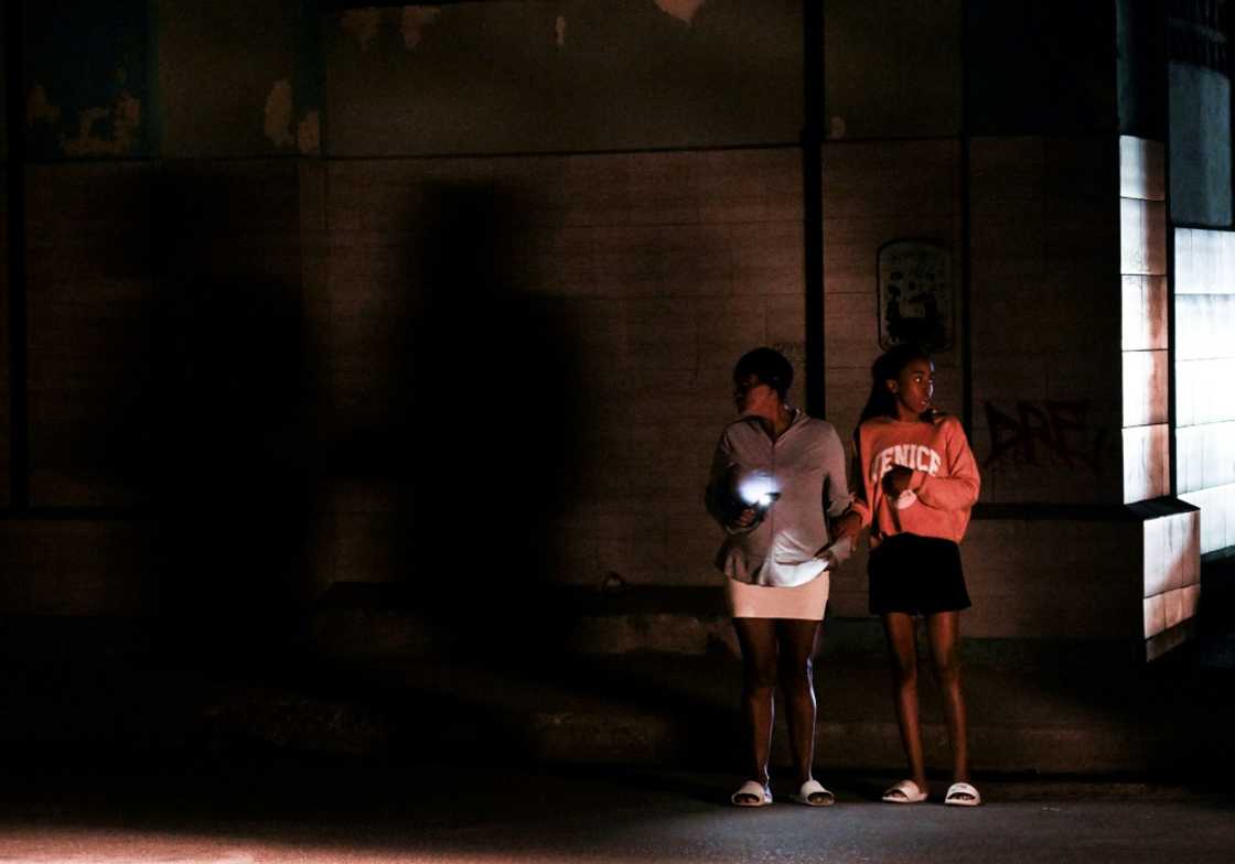 Cubans stand on a corner during a general blackout in Havana on March 14, 2025