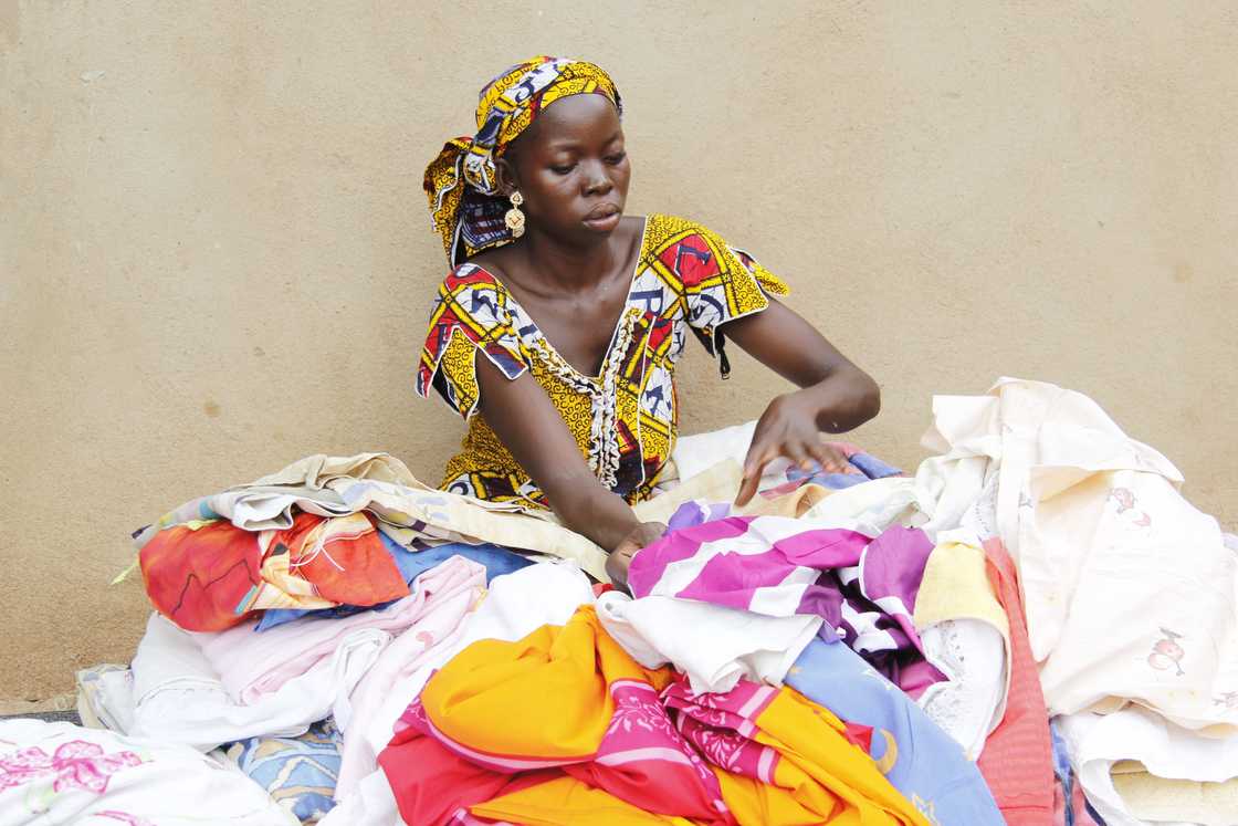A woman selling second-hand clothes at a market.