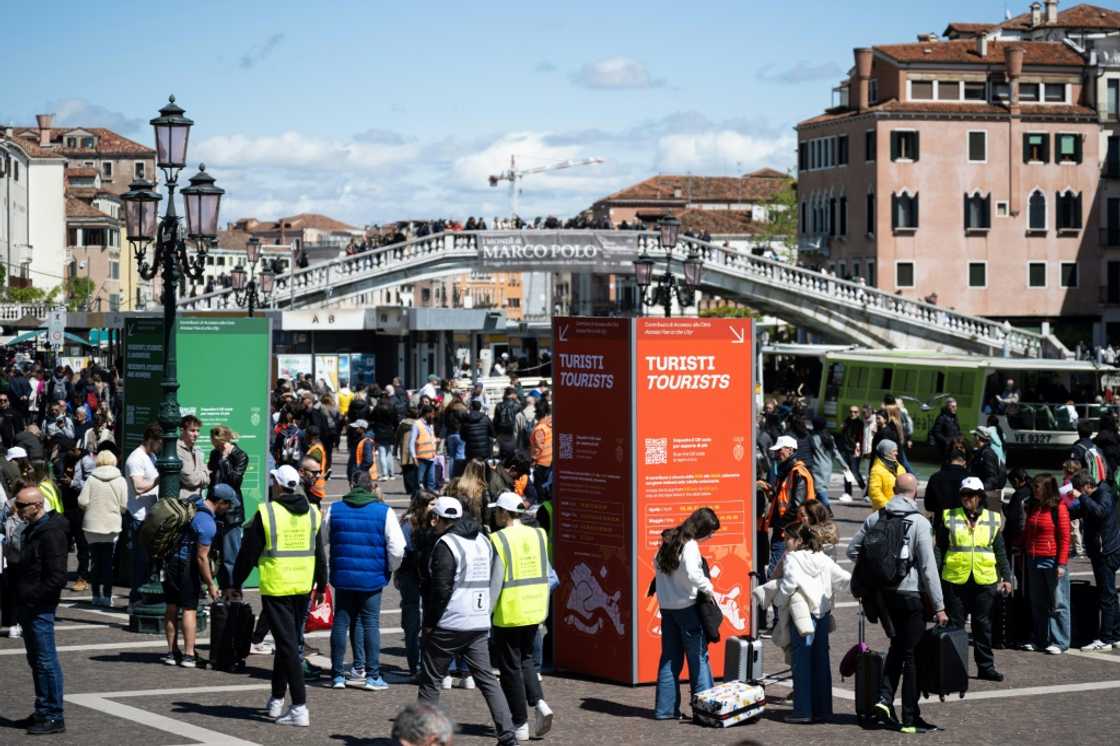 Tourists wait to pass controls to enter Venice's city centre after the UNESCO World Heritage site put into place a five-euro fee for day-trippers to visit