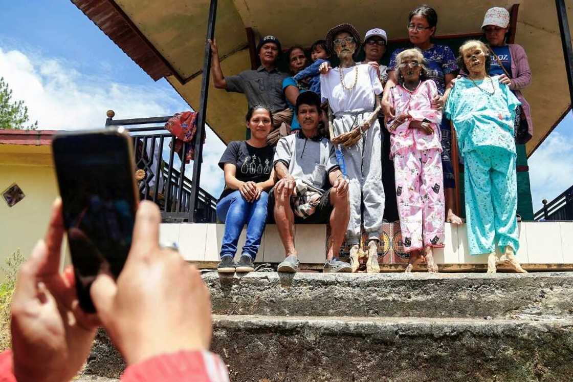 An Indonesian family poses with a dead relative as part of a ritual celebration of the afterlife An Indonesian family poses with a dead relative as part of a ritual celebration of the afterlife