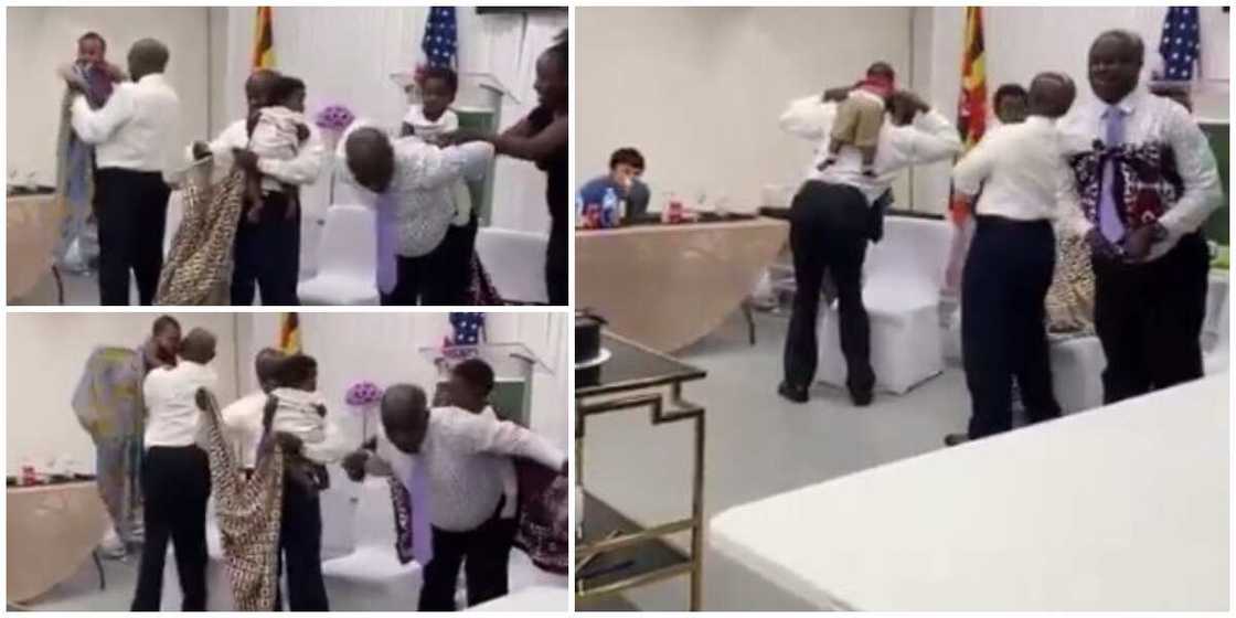 Fathers on corporate wear attempt to carry babies on their backs with wrappers in adorable video Fathers on corporate wear attempt to carry babies on their backs with wrappers in adorable video