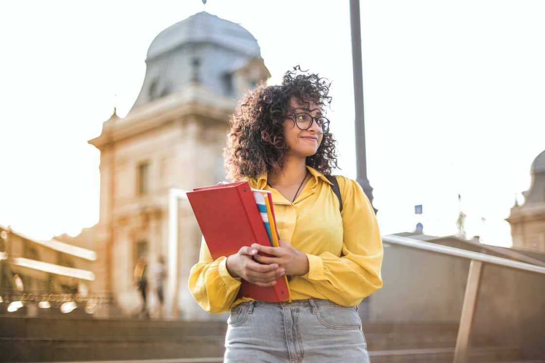 A student in yellow top holding books