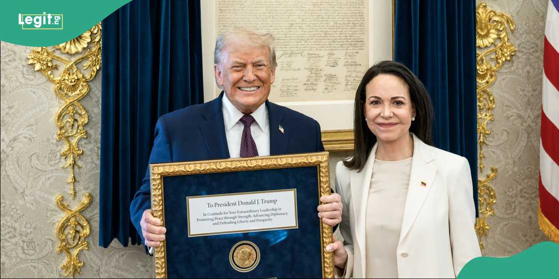 Donald Trump holding a Nobel Peace Prize medal during a White House meeting with Maria Corina Machado