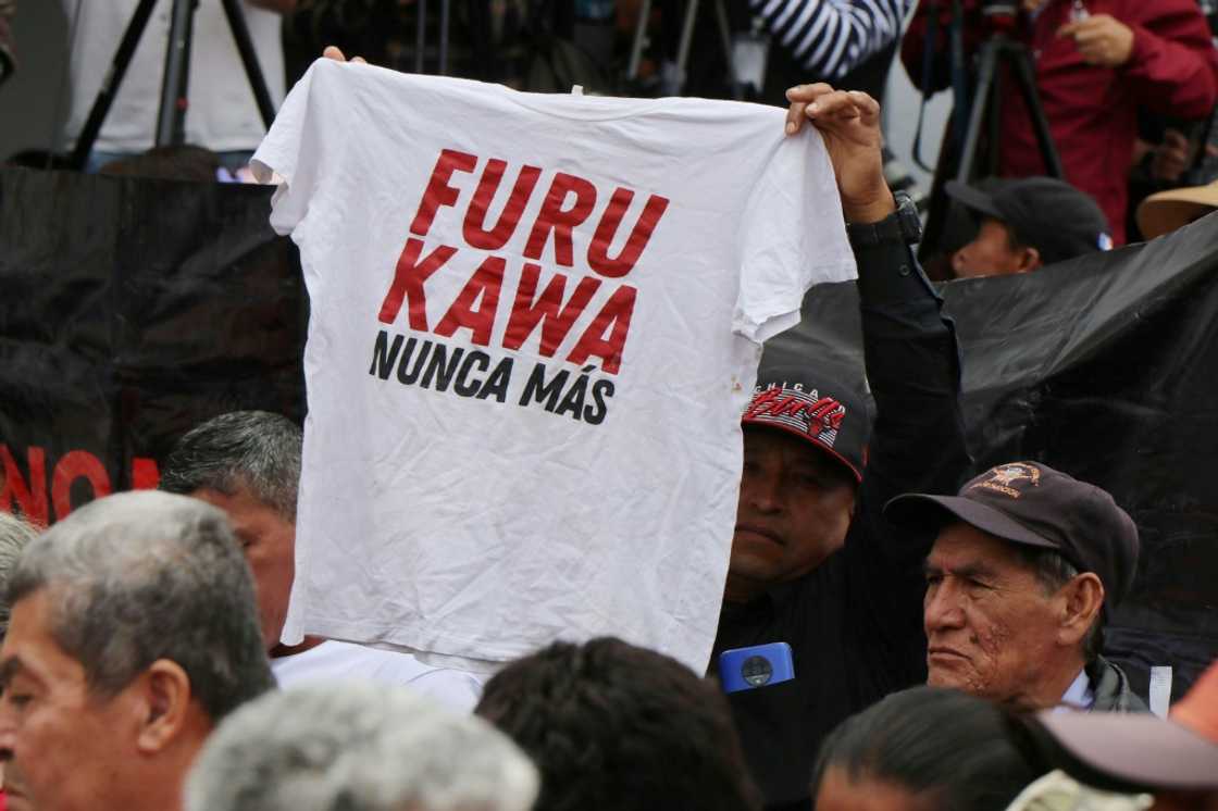 A man in Ecuador holds up a shirt with the slogan 'Furukawa, never again,' alluding to a Japanese textile firm found to have abused its workers A man in Ecuador holds up a shirt with the slogan 'Furukawa, never again,' alluding to a Japanese textile firm found to have abused its workers