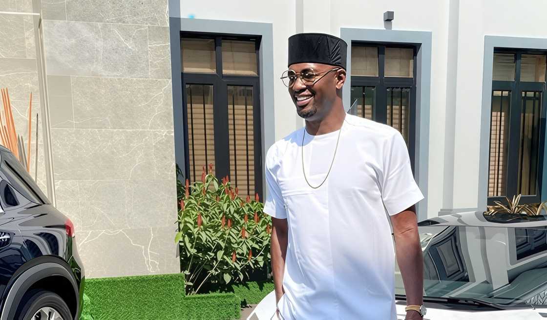 Joseph Eze Okafor (Jr.) seen wearing a traditional Nigerian outfit, in front of a building and cars Joseph Eze Okafor (Jr.) seen wearing a traditional Nigerian outfit, in front of a building and cars