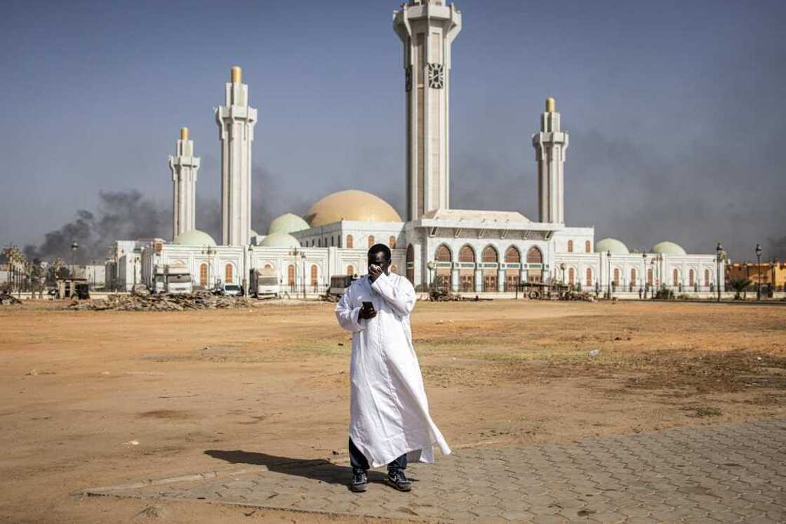A man covers his face to protect from tear gas as protesters clashed with police in Dakar last week A man covers his face to protect from tear gas as protesters clashed with police in Dakar last week