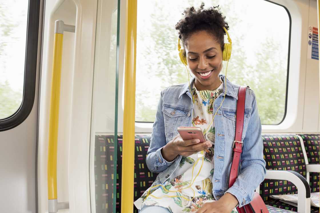 A woman using a phone on a train A woman using a phone on a train
