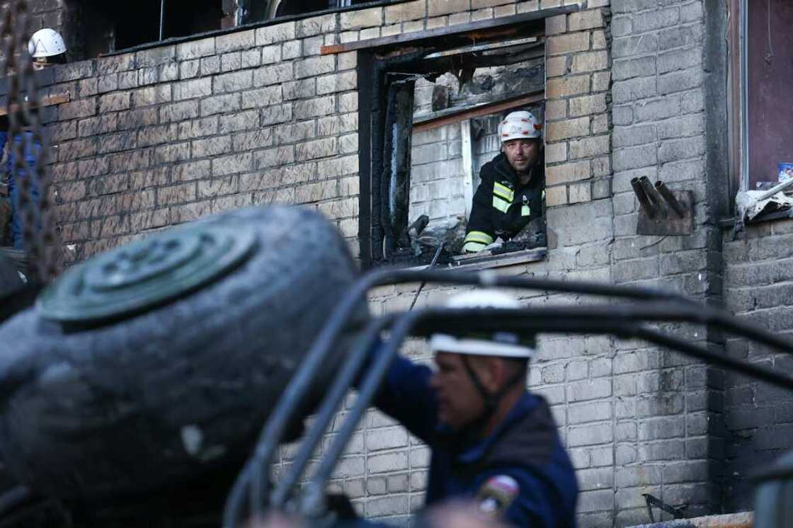 Russian emergency services remove the wreckage of a Sukhoi Su-34 military jet after it crashed in the town of Yeysk in southwestern Russia