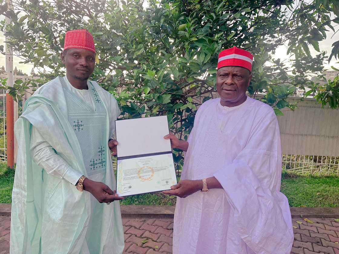 Haruna Rogo yana nuna wa Kwankwaso shaidar gama digirin PhD Haruna Rogo yana nuna wa Kwankwaso shaidar gama digirin PhD