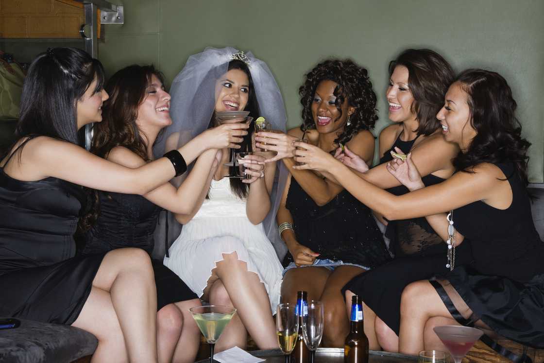 Friends drinking cocktails with bride-to-be