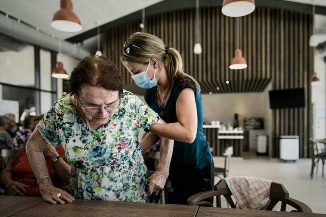 A volunteer attends to Alzheimer's patients at a center for Alzheimer's patients in Dax, southwestern France A volunteer attends to Alzheimer's patients at a center for Alzheimer's patients in Dax, southwestern France