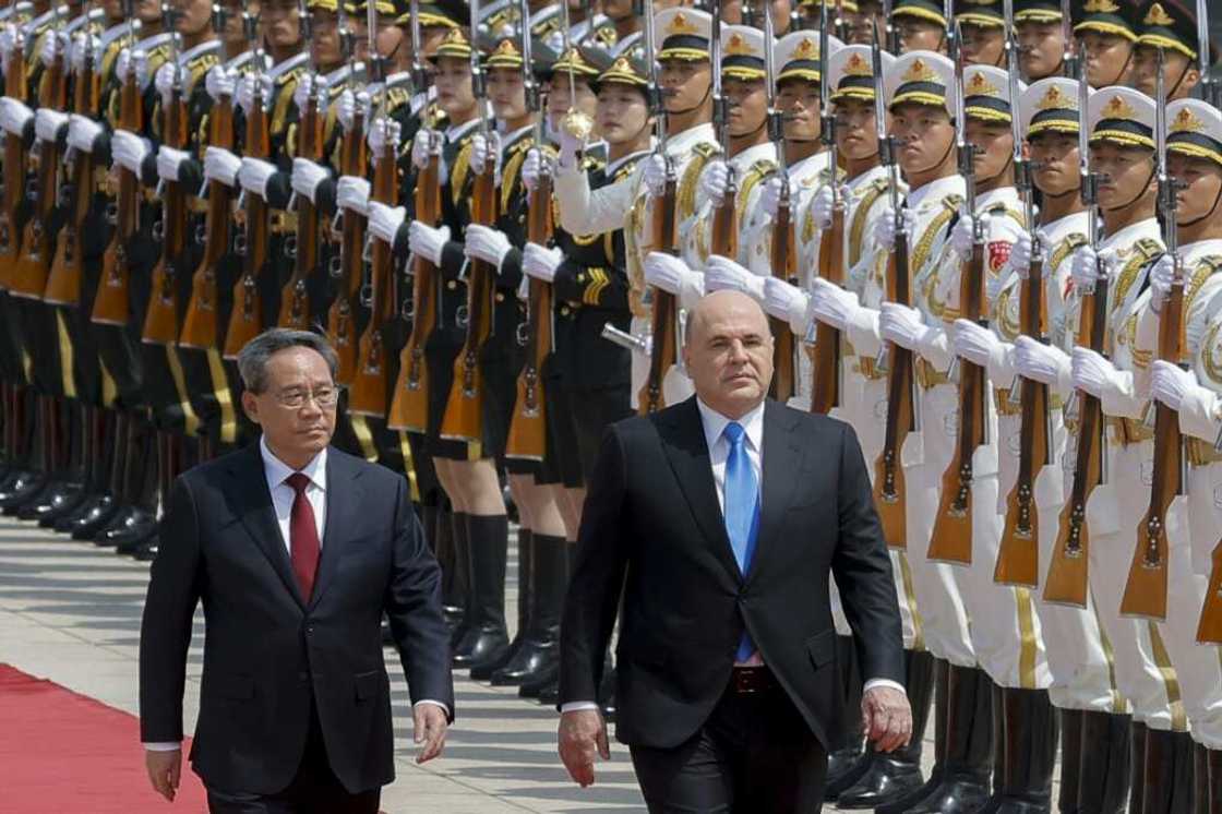 Russian Prime Minister Mikhail Mishustin (R) and Chinese Premier Li Qiang attend a welcoming ceremony in Beijing on May 24, 2023