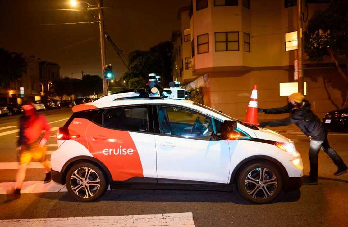 Activists from SafeStreetRebel shown in July placing a cone on a self-driving Cruise robotaxi to disable it in San Francisco