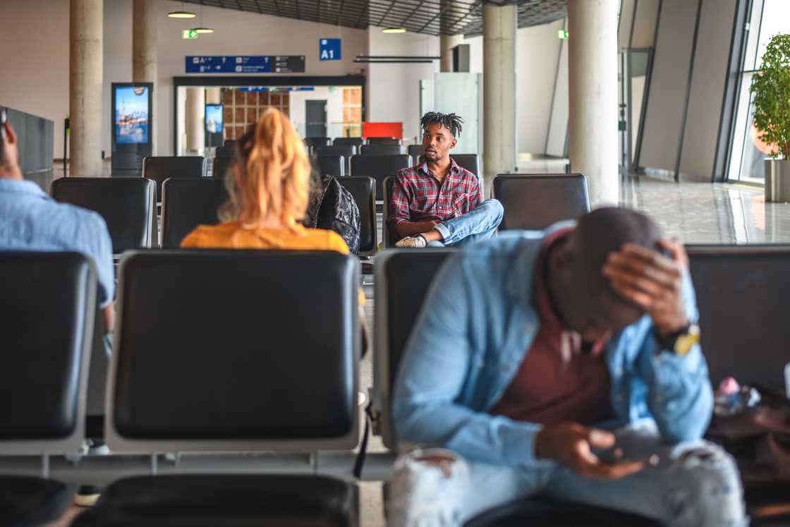 Grieving travellers, phones glowing with tragic updates. Grieving travellers, phones glowing with tragic updates.