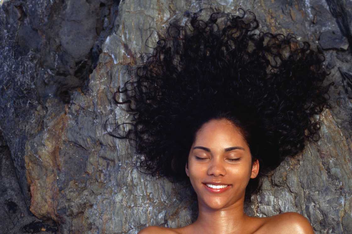 A woman lying on the rock with hair fanned out A woman lying on the rock with hair fanned out
