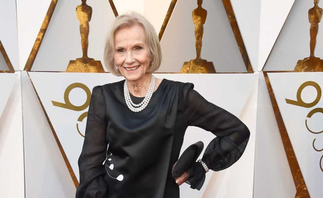 Eva Marie Saint poses in a black gown, white pearl necklace, and a clutch bag at the 90th Annual Academy Awards