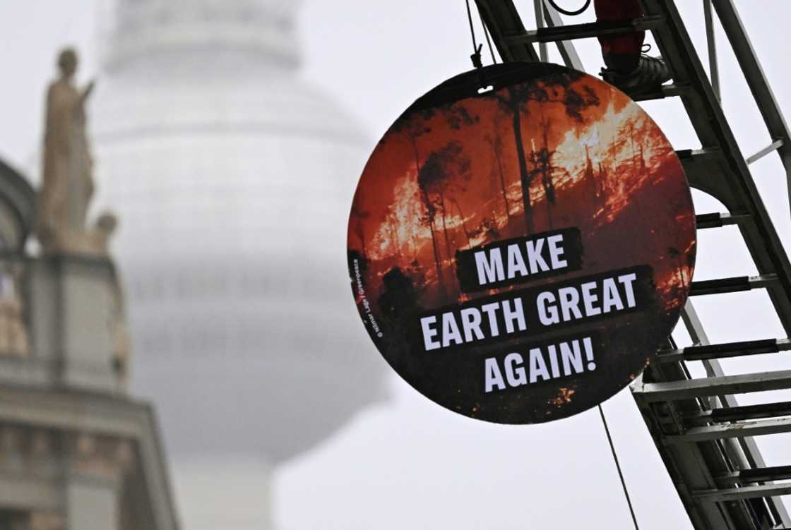 A Greenpeace activist installs a placard reading 'Make Earth Great Again' outside Germany's foreign ministry, which was hosting the climate talks A Greenpeace activist installs a placard reading 'Make Earth Great Again' outside Germany's foreign ministry, which was hosting the climate talks