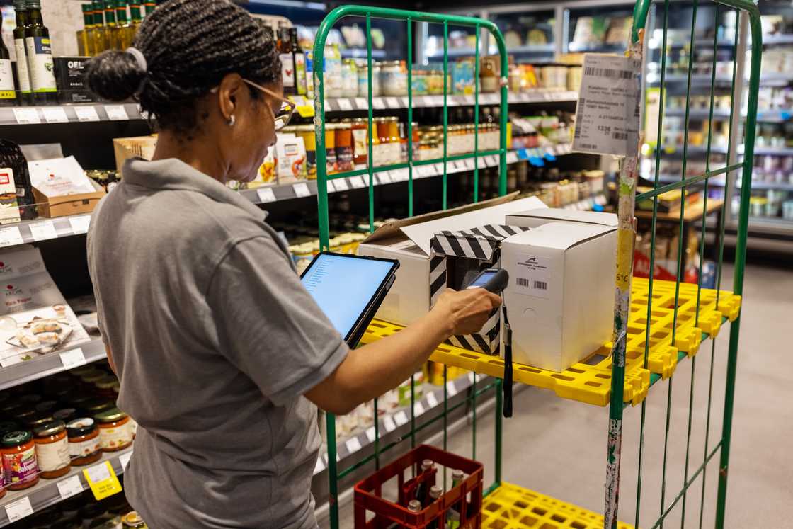 A woman scanning a label on box using a portable scanner A woman scanning a label on box using a portable scanner