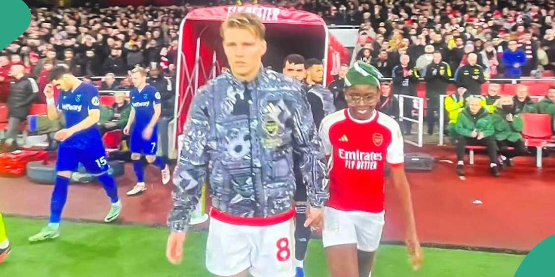Boy walks into pitch with Martn Odegaard. Boy walks into pitch with Martn Odegaard.