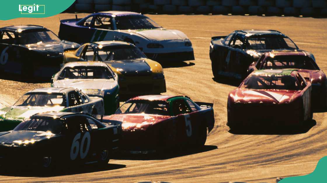 Stock cars racing around curve in track Stock cars racing around curve in track