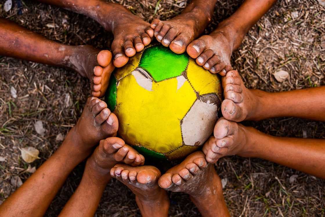 Kids with a worn out football Kids with a worn out football