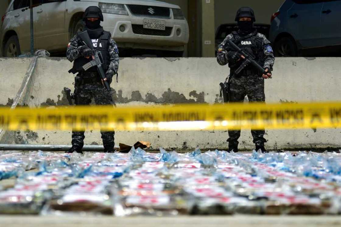 Ecuadoran anti-narcotics police stand guard next to packs of cocaine from a 3-ton shipment seized from a container of bananas in the port of Guayaquil in April 2022 -- Ecuador has become a battleground for criminal gangs involved in the drugs trade Ecuadoran anti-narcotics police stand guard next to packs of cocaine from a 3-ton shipment seized from a container of bananas in the port of Guayaquil in April 2022 -- Ecuador has become a battleground for criminal gangs involved in the drugs trade