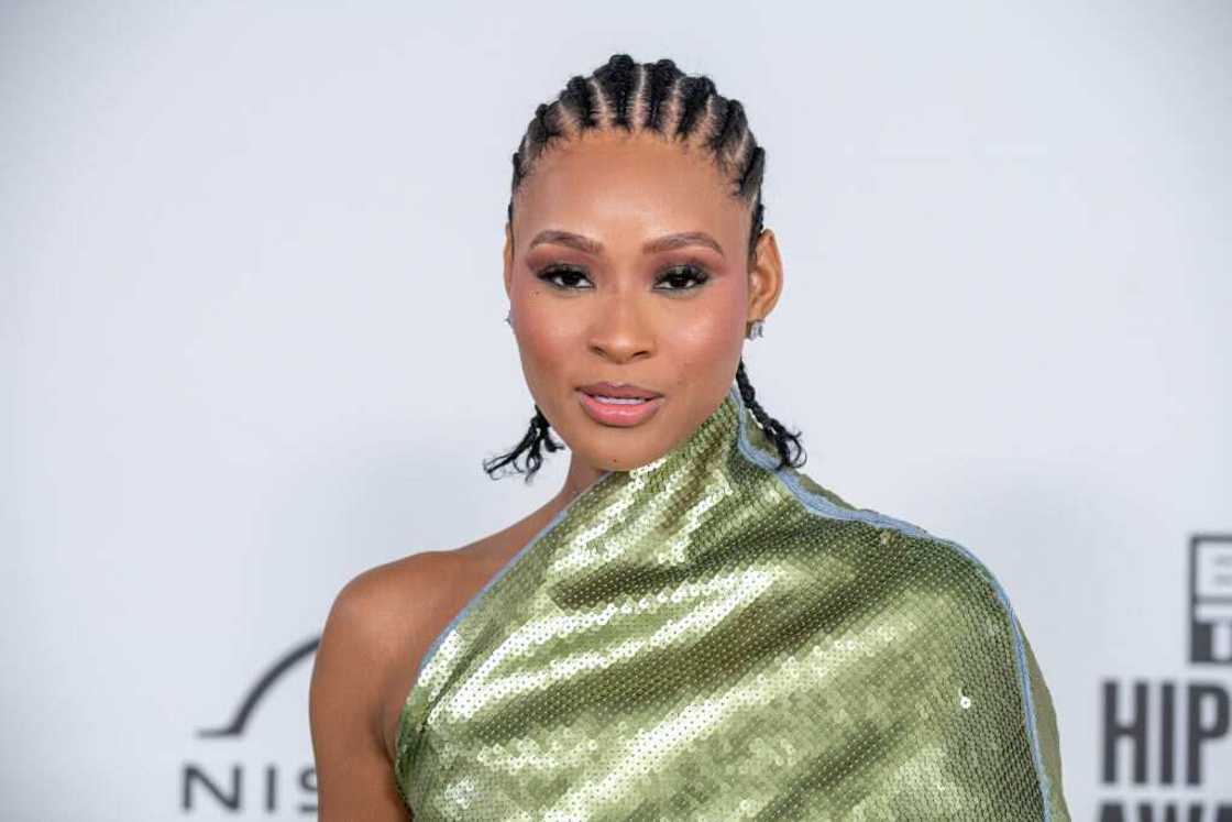 Pretty Vee posing for a photo in a gold dress at the BET Hip Hop Awards at Cobb Energy Performing Arts Center